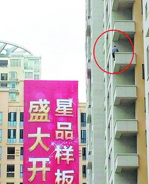 該男子爬上高樓，半身懸空，十分危險