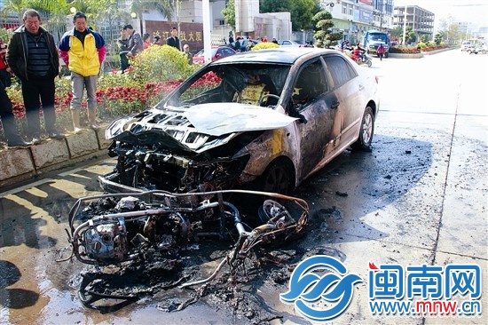 火被撲滅后，小車前躺著一輛被燒得只剩鋼架的助力車