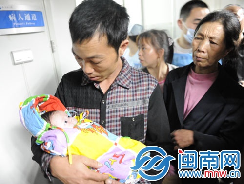 寶寶在叔叔的懷中，睜著大眼好奇地張望著
