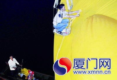 工人給大黃鴨系上繩子，準備起吊