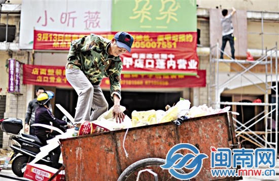 為了裝下更多垃圾，爬上垃圾車將垃圾踩實(shí)