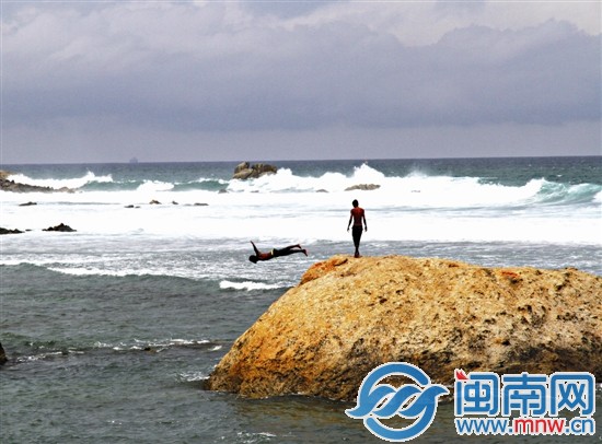 加勒海邊玩跳水的少年一遍遍跳入水中