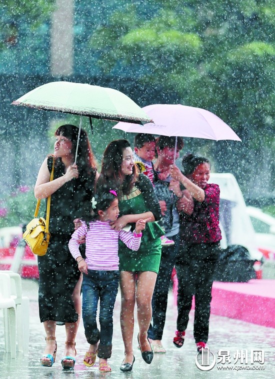 在泉州市區(qū)寶洲街，市民雨中出行
