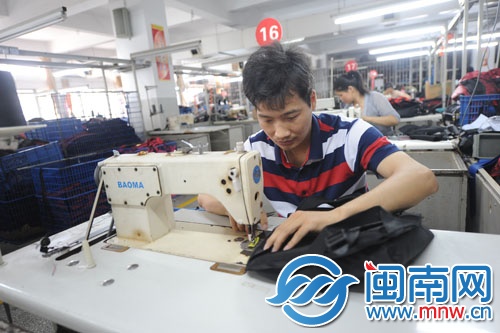 一名職工正認真地縫包