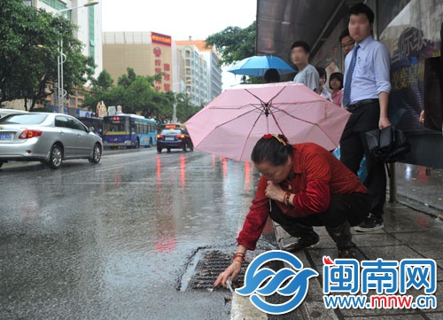 吳阿婆在泉秀街撿垃圾疏通雨水井口