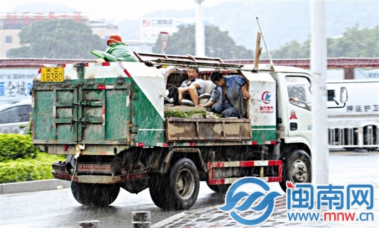 泉州市區(qū)坪山路，幾名工人在貨車車斗避雨不及