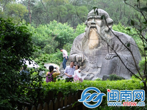 一游客爬上老君巖拍照
