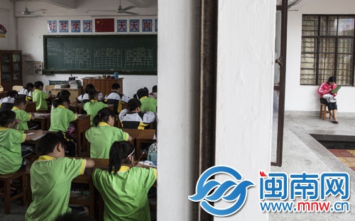 兒子在教室內(nèi)上課，母親怕自己睡著，在教室外鉤著毛