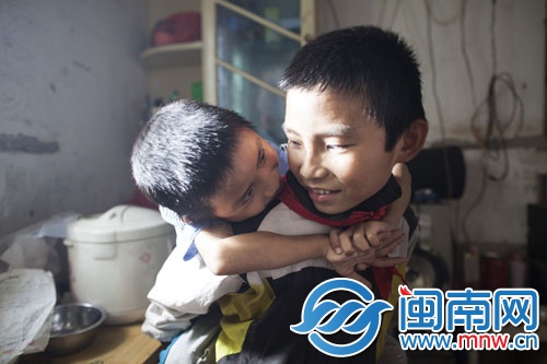 每次摔倒，哥哥就將弟弟抱起
