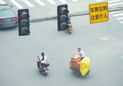闖紅燈、不戴頭盔現(xiàn)象時(shí)有發(fā)生。本報(bào)記者陳明哲攝