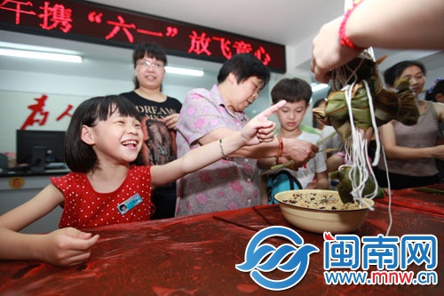 孩子開心地指著自己包好的粽子