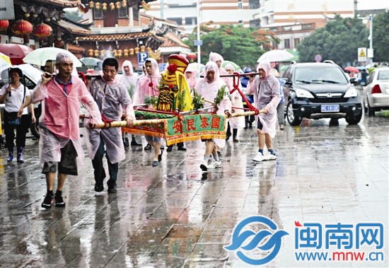 抬著神像，冒雨踩街祈福