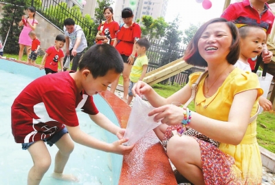 市第二幼兒園孩子與家長(zhǎng)一起玩抓泥鰍。