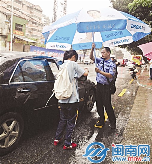 廈門一中考場外，一名民警幫考生撐傘