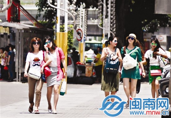 昨天天氣晴好，陽(yáng)光強(qiáng)烈，市區(qū)泉秀街上幾位美女戴著