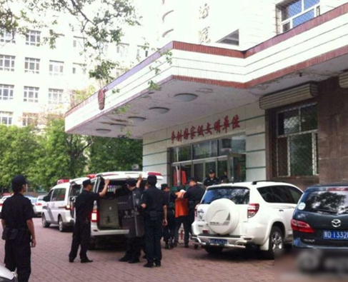 兩名犯罪嫌疑人頭戴面罩，被法警押進(jìn)法庭。2