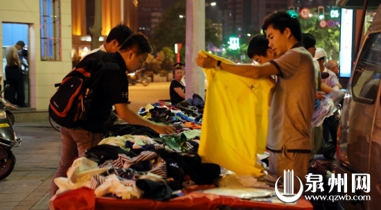 市區(qū)田安路與豐澤街交叉路口，市民正在一攤點(diǎn)前挑選