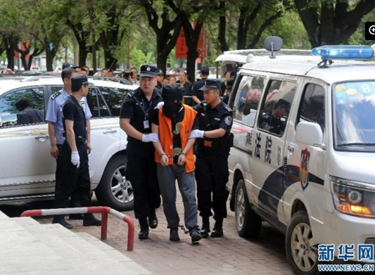 兩名犯罪嫌疑人頭戴面罩，被法警押進法庭。