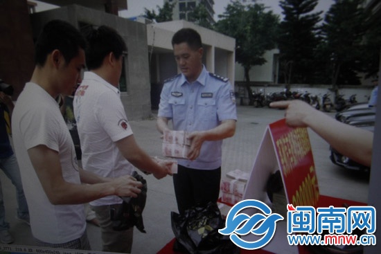 受害人陳先生從民警手中領(lǐng)回被騙的40萬(wàn)元