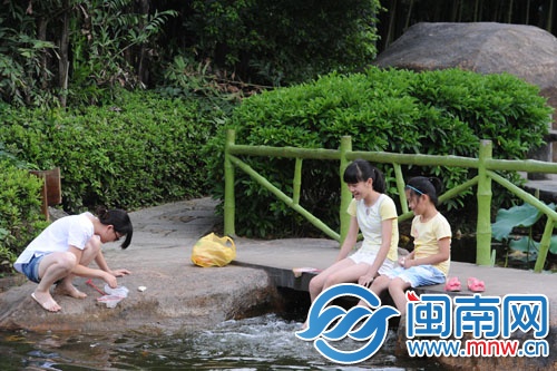 天氣太熱，坐在水邊玩水，讓腳涼快些