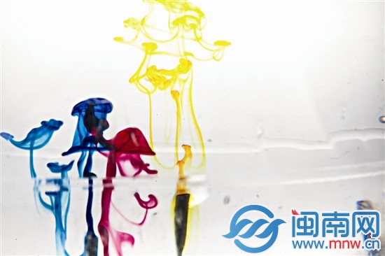 畫筆剛接觸水面，顏色在透明的水里散開，像是一只只