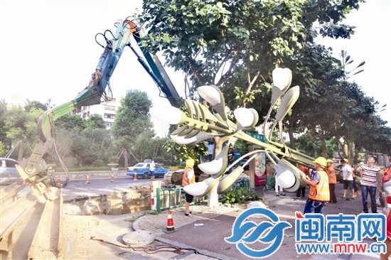 大坑邊的一座路燈暫時(shí)被拆卸，壓樁機(jī)正在打樁