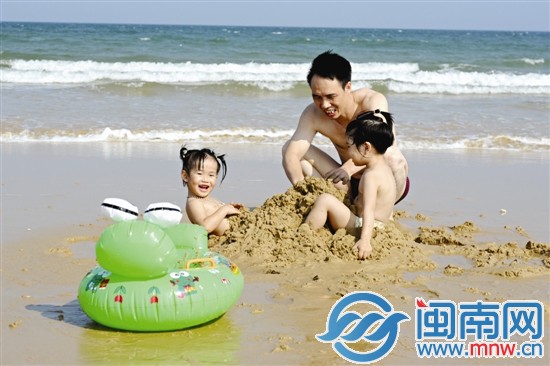 父親帶著小孩到泉州張坂海域的海灘玩沙