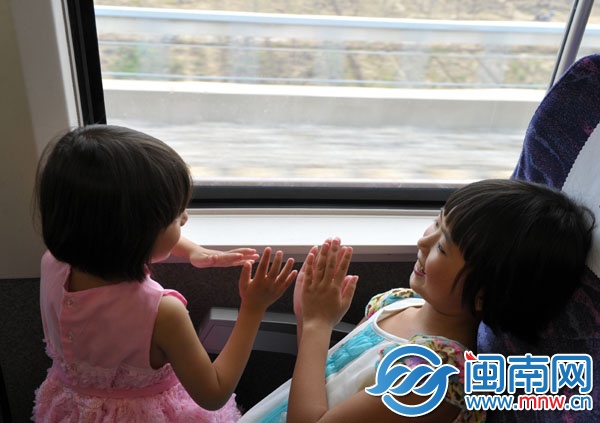 動(dòng)車(chē)上，朱心琴姐妹玩拍手游戲打發(fā)時(shí)間