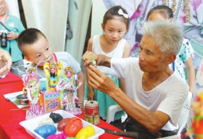 肖其昌在傳授小朋友妝糕人制作技藝。