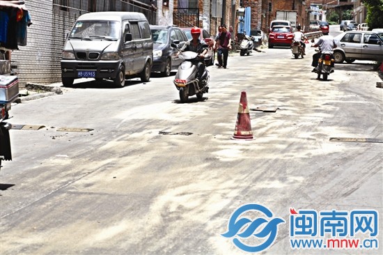 津?qū)毬飞系挠臀?，兩個好心人已經(jīng)用沙子鋪在路上