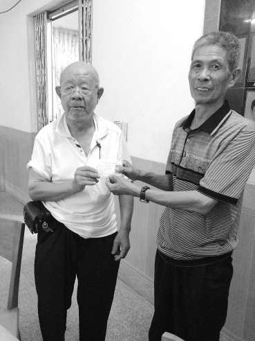 吳基揚(yáng)（左）將辦好的證件遞交給村民。