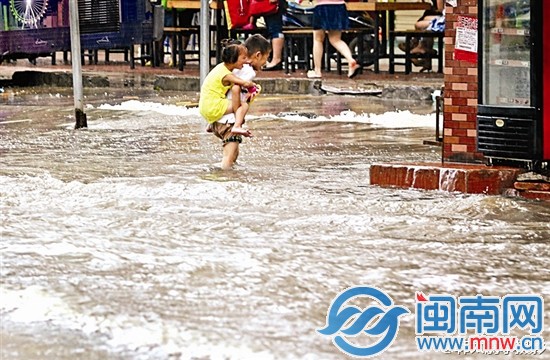 小哥哥背著小妹妹艱難涉水