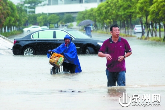 市民趟水前行，一輛車在水中拋錨